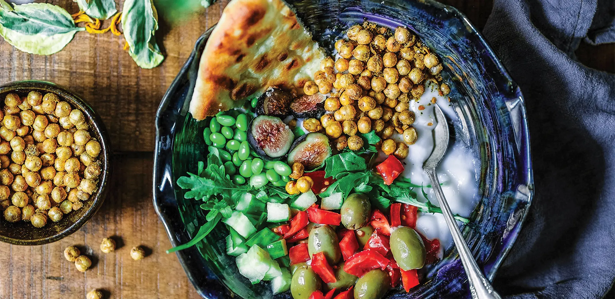 Photo of a silver spoon in a bowl of mixed vegetables.