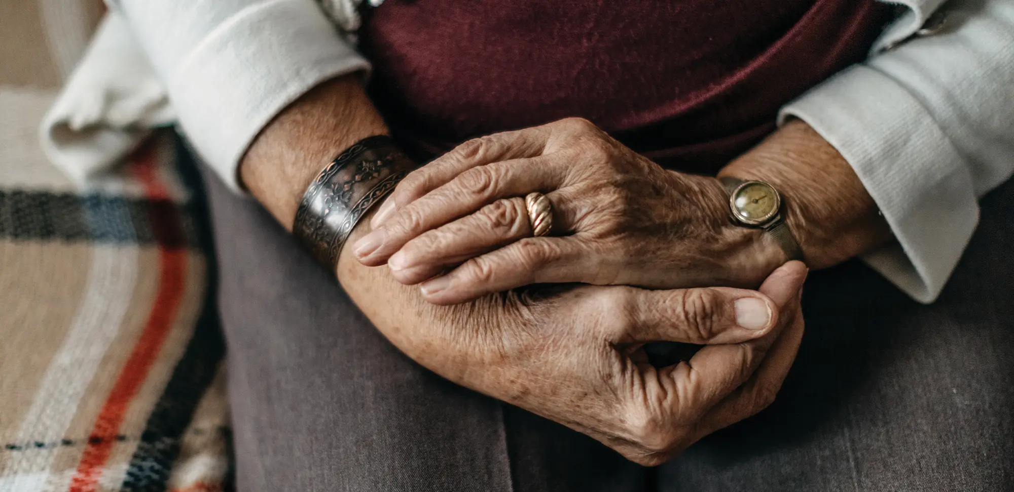 Photo of an elderly person with their hands in their lap.