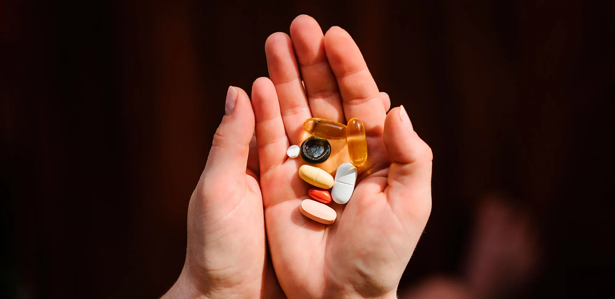 Photo of a woman's hands holding multivitamins