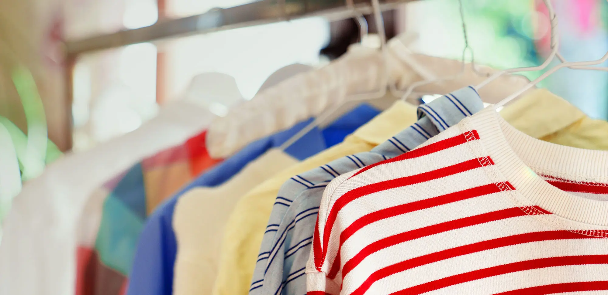 Photo of a close up of clothes hanging on a rail.