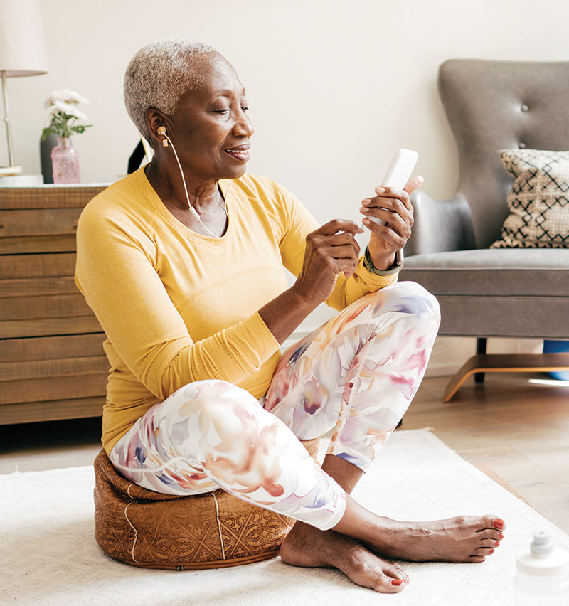 Femme âgée suivant les instructions de bien-être en ligne sur son téléphone intelligent