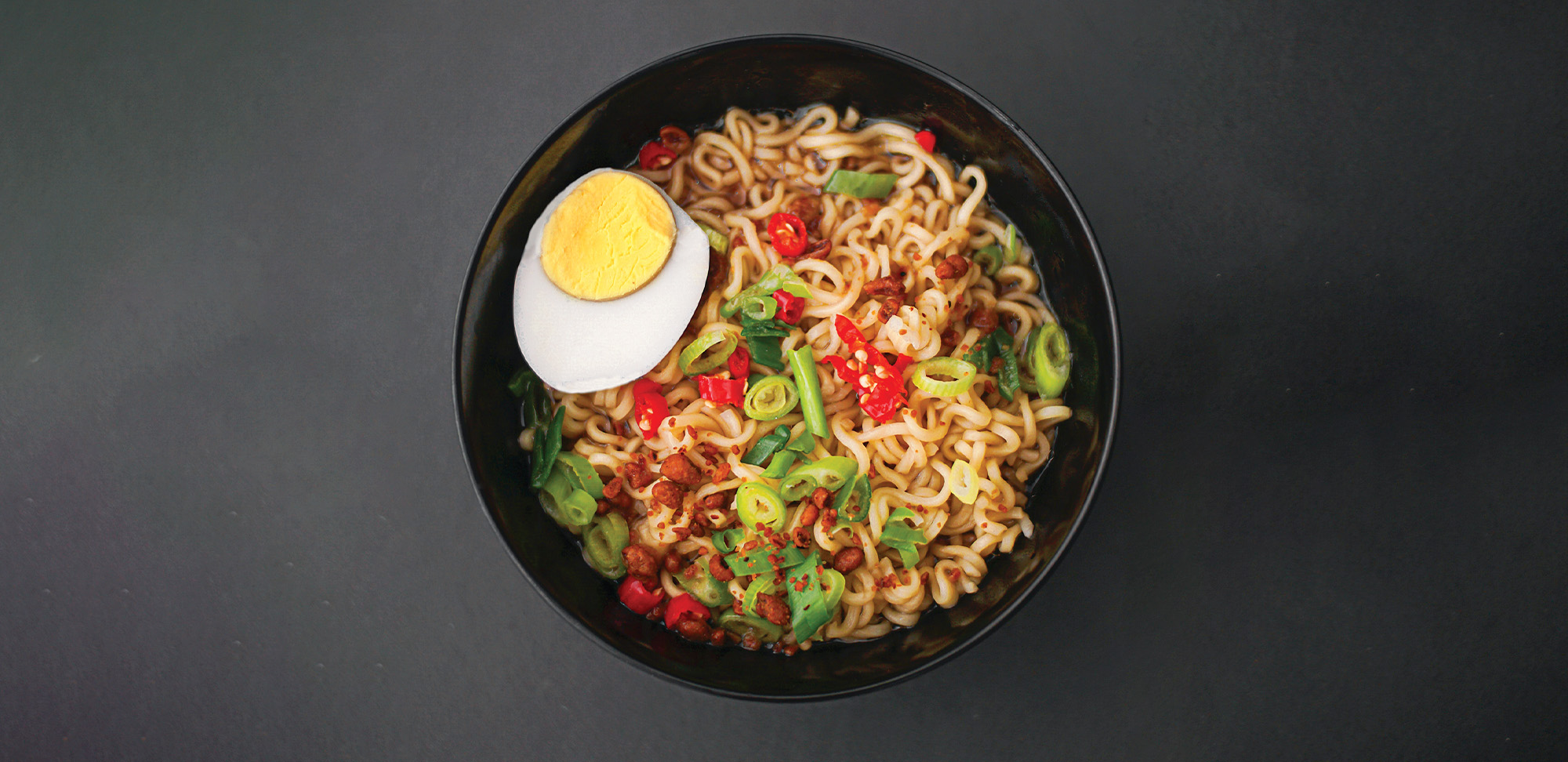 Bowl of noodles with green onion and egg