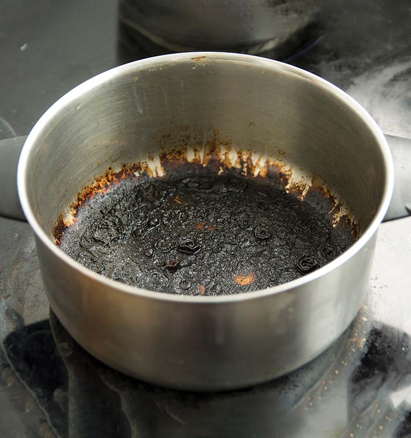 Photo d’une casserole vide brûlée avec un fond noir
