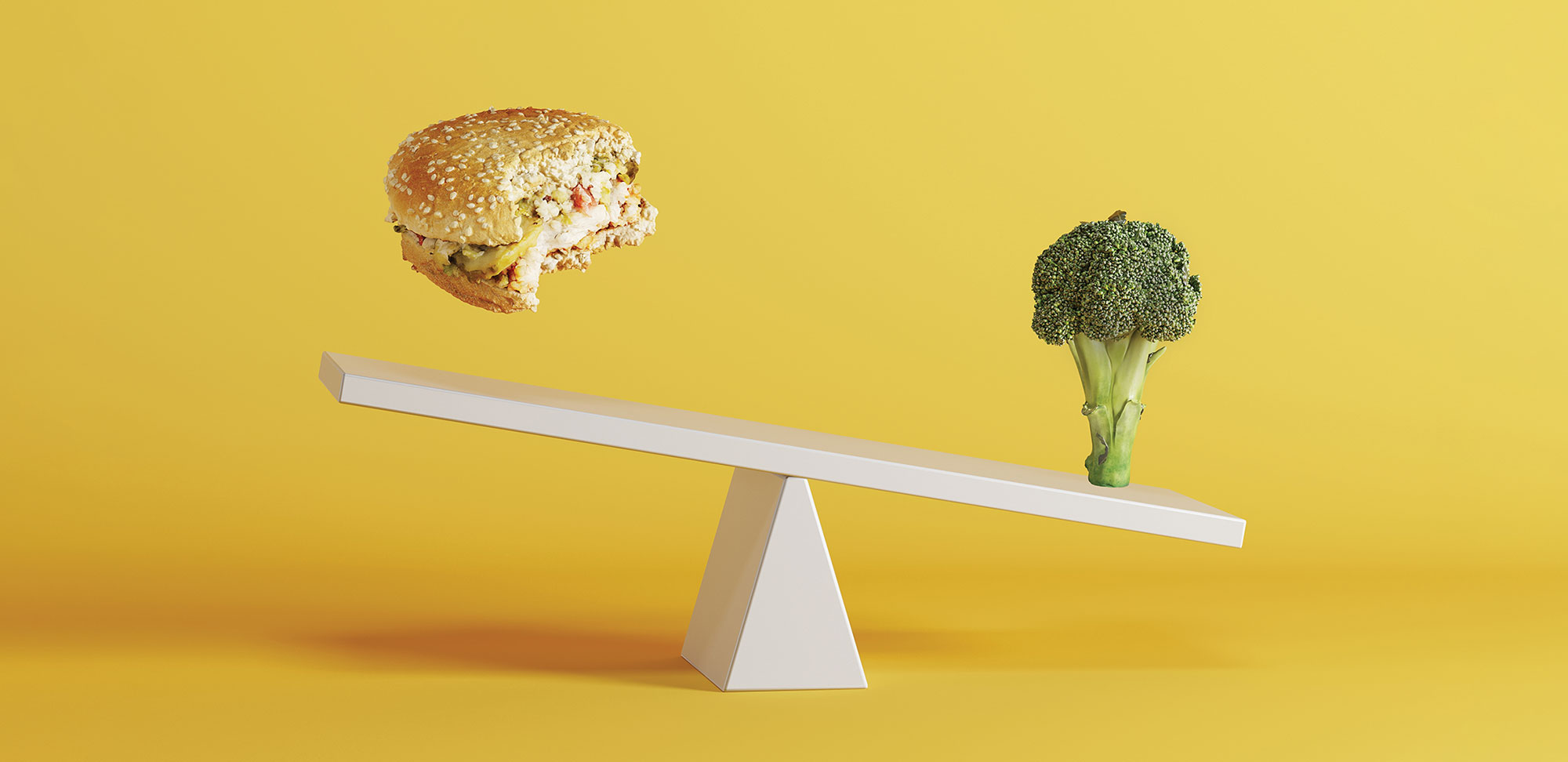 Photo of broccoli vegetable tipping seesaw with floating berger on opposite end on yellow background.